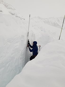 SLF snow physicist Lars Mewes creates a snow profile in poor visibility. (Photo: Lars Mewes / SLF)
