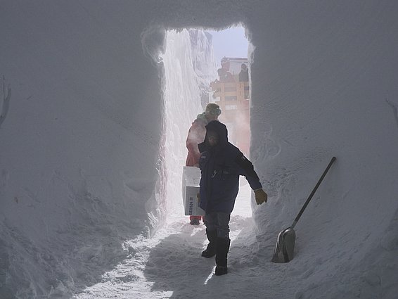 Putting the boxes (several dozen a week) into storage requires (wo)manpower. The boxes weigh around forty kilograms each and have to be carried into the cave from the transport sledge. (Photo: Matthias Jaggi / SLF)