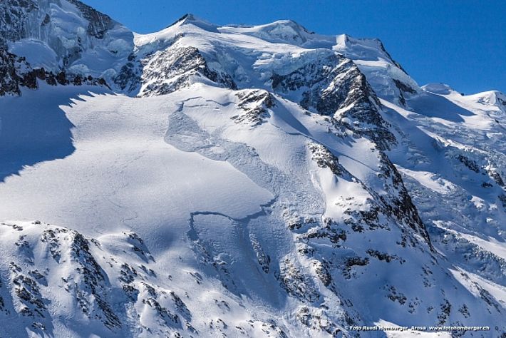 Abb. 1: Zu Beginn dieser Berichtsperiode waren die Lawinen der vorangehenden Woche noch allgegenwärtig. Hier jene vom10.03., fernausgelöst von einem Skifahrer. Nordhang auf etwa 3100 m an der „Gemsfreiheit“ (Vadret da la Fortezza, Pontresina, GR). Im Hintergrund die vier Gipfel der Bellavista, rechts hinten der 3945 m hohe Piz Argient. © R. Homberger.