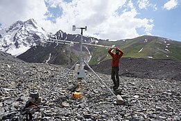 Stefan Fugger installe notre station météorologique automatique sur le glacier Kyzylsu couvert de débris. Photo : A. Jouberton