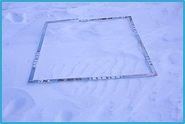 Quadratischer Rahmen aus Metall auf schneebedecktem Boden, mit Messmarkierungen an den Seiten