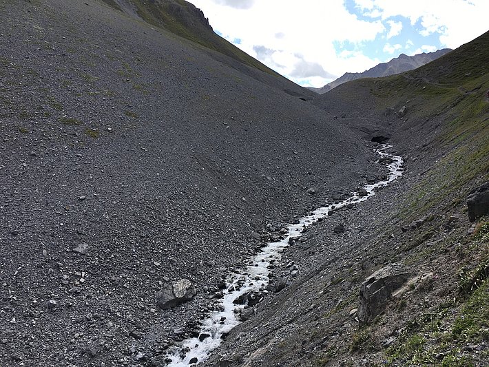 Natürliches Snowfarming in Davos, GR: schuttbedeckte, vermutlich mehrjährige Schneereste im Ducanbach auf rund 2150 m (Foto: SLF/L. Dürr, 22.08.2017).