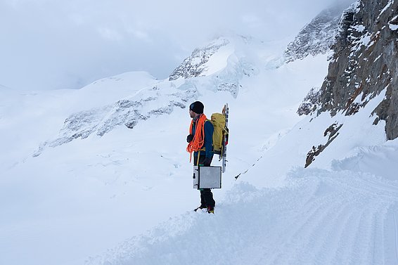 With rope, saw and case: Lars Mewes, snow physicist at the SLF, on his way to work at the Jungfraujoch. (Photo: Lars Mewes / SLF)