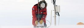 Starke Winde sind in Polarregionen keine Seltenheit. Diese erschweren auch die Feldarbeiten: Ein Forscher misst mit dem SnowMicroPen neben einer Messstation des Greenland Climate Networks auf dem grönländischen Eisschild. Bild: Martin Proksch, SLF