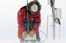 Starke Winde sind in Polarregionen keine Seltenheit. Diese erschweren auch die Feldarbeiten: Ein Forscher misst mit dem SnowMicroPen neben einer Messstation des Greenland Climate Networks auf dem grönländischen Eisschild. Bild: Martin Proksch, SLF