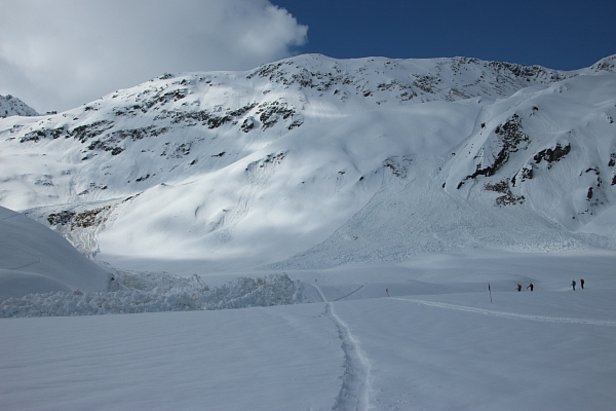 Abb. 5: Ablagerung einer grossen Lawine, abgegangen an der Ostflanke des Fil Tuma (Tujetsch, GR). Die Lawine hat sich am Freitag, 24.03. auf rund 2600 m spontan gelöst. Der Bruch erfolgte in tiefen Schichten und es wurde die ganze Schneedecke mitgerissen. Die nasse Ablagerung stiess dabei ausserordentlich weit ins Flache vor. Die Lawine erreichte eine Länge von über 2 km (Foto: R. Koehler, 25.03.2017).