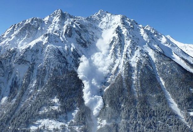 Photo 29: Après les fortes chutes de neige, il a fallu prendre des mesures dans de nombreuses régions afin de sécuriser les routes et les domaines skiables, comme ici sur la route menant à Samnaun (GR). Cette avalanche poudreuse a été déclenchée au Piz Mundin à l’aide d’une charge explosive lancée d’un hélicoptère (photo: P. Caviezel 03.04.2015).