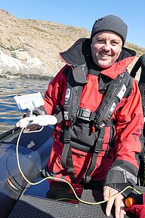 Makroalgen (Seetang) sind an der grönländischen Küste weit verbreitet und spielen eine Schlüsselrolle in der biologischen Kohlenstoffpumpe der Ozeane. Joe Marlow (Universität Aarhus) steuert die 2 kg-schwere Unterwasserdrohne und bestimmt die Bedeckung und Artenvielfalt der Makroalgen auf dem Meeresgrund mittels Videoaufnahmen. (Foto: Beat Frey)