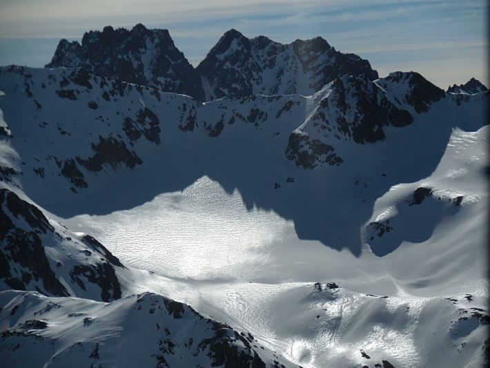 Die Sonne brachte den Firnspiegel im Kessel südöstlich des Scalettahorns (3067 m, S-chanf, GR) zum Glänzen. Er entsteht im Frühling durch das Zusammenspiel aus Sonneneinstrahlung, Schmelzen, Windeinfluss und Abstrahlung. Im Hintergrund ist der Piz Vadret (3229 m) sichtbar (Foto: SLF/L. Dürr, 12.04.2017).