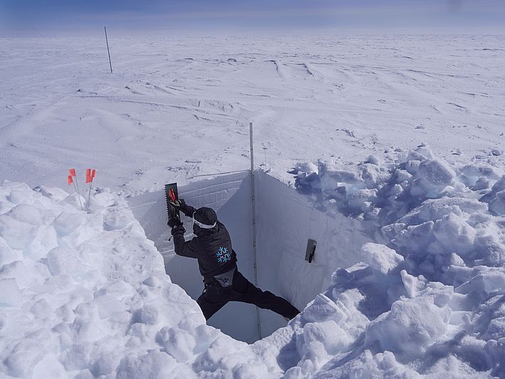 Beim zweieinhalb Meter tiefen Schneeprofil muss ich mich manchmal ganz schön strecken und in den Seitenwänden verspannen, fast wie beim Kaminklettern. Mit der Maurerkelle versuche ich, eine möglichst plane Profilwand zu machen, was noch nötig ist für die SnowImager-Messung. (Foto: Matthias Jaggi / SLF)