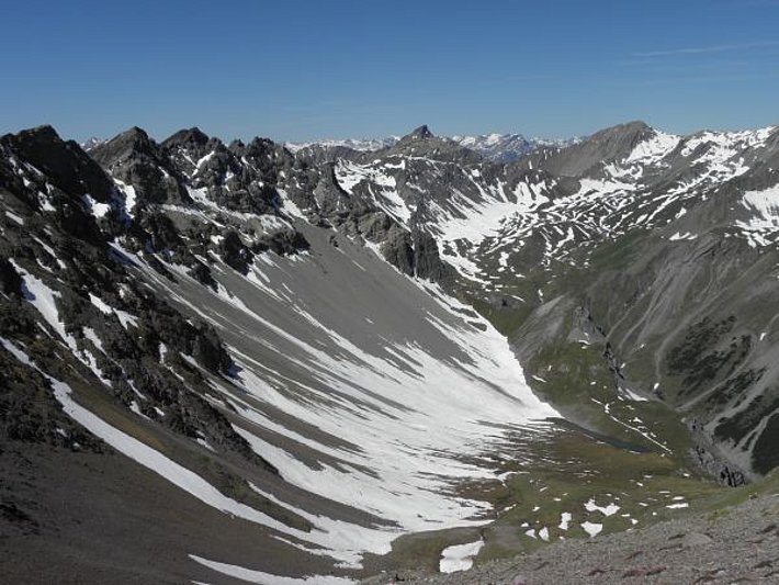 Mitte Juni lag Schnee in hohen Lagen v.a. noch in Rinnen und Mulden, oder an nordseitigen Hangfüssen, wo im Winter Lawinenschnee abgelagert wurde. Im Bild war dies in Höhenlagen oberhalb von etwa 2300 m. Blick vom Sandhubel (Davos, GR) Richtung Westen zum Lenzerhorn (2906 m), ganz im Hintergrund mit den Gipfeln des Rheinwaldes (Foto: SLF/Th. Stucki, 11.06.17).