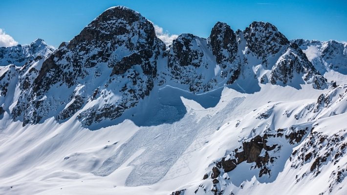 Photo 1: Spontanée ou déclenchée par des adeptes des sports d’hiver? Cette avalanche de plaque de neige sèche au Vadret da Radönt (Zernez, GR) s’est décrochée à environ 2900 m sur une pente exposée au nord, qui avait une déclivité de plus de 30° uniquement dans sa partie supérieure. Elle a enseveli une grande partie de la montée normale vers le Radüner Rothorn (photo: R. von Allmen, 10.05.2017).