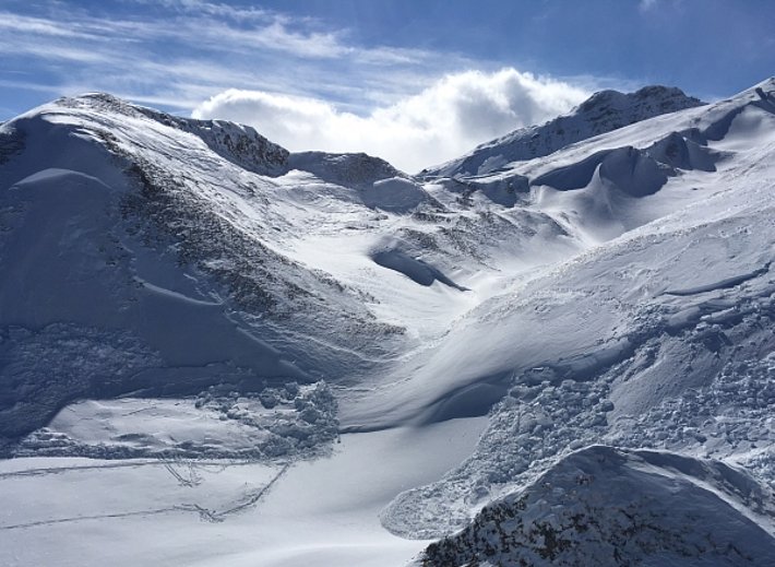 Ablagerung von zwei Schneebrettlawinen im südlichen Teil des Camaner Grates, die linke wurde vom Hangfuss fernausgelöst (ca. 2500 m, Exposition Nord), zwei Personen wurden dabei teilverschüttet. Die rechte Lawine wurde ebenfalls fernausgelöst (ca. 2500 m, Exposition Ost). Im Hintergrund ist das Tällihorn sichtbar (2855 m, Safiental, GR). Abgeglitten ist der frische Triebschnee, der mit dem kräftigen Südwind entstanden war (Foto: N. Mocklaus, 11.02.2017).