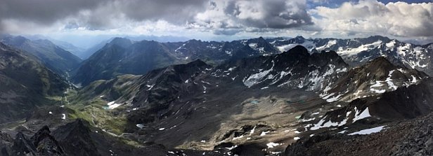 Abb. 3: Unbeständiges Wetter am Samstag, 08.07. Gewitter, vor allem in der zweiten Tageshälfte, prägten das zweite Juliwochenende. Beim Blick vom Flüela Schwarzhorn Richtung Osten (links im Bild) und Süden (rechts im Bild) sind nur noch wenige Schneereste oberhalb etwa 2800 m und die schon stark ausgeaperten Gletscher sichtbar (Foto: SLF/F. Techel).