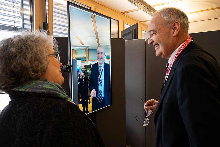 Sabine Süsstrunk, chercheuse à l'EPFL, explique au conseiller fédéral Guy Parmelin comment les deep fakes lui permettent de découvrir de nouvelles perspectives et de nouveaux objets grâce à des techniques informatiques avancées. (Photo : Luzia Schär)