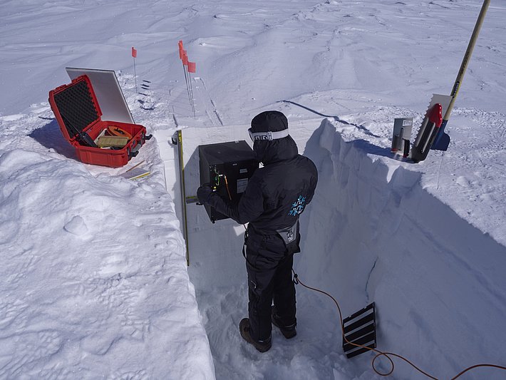 Working with the SnowImager in the snow profile. (Photo: Matthias Jaggi / SLF)