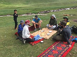 Des enfants offrent à Evan Miles, Stefan Fugger et Pascal Buri des yaourts et du pain avant de les défier pour un match de football. Photo : A. Jouberton