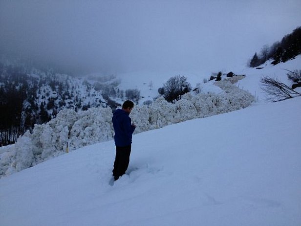 Abb. 1: Diese grosse Nassschneelawine ging in der Nacht des 23. Dezembers – am lawinenaktivsten Tag im Winter 12/13 – kurz nach Leweren (Wassen, UR) aus einem Südwesttobel auf die Hauptstrasse nieder. Dort wurde sie von bereits vorhandenen Schneemauern abgelenkt und folgte der Strasse Kurve um Kurve rund 150 m weit das Meiental hinaus in Richtung Husen. Es entstand erstaunlicherweise kein Sachschaden (Foto: H.-M. Henny, 23.12.2012).