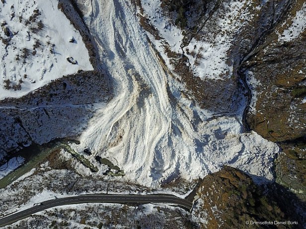 Abbildung 4: Ablagerung der Golperlouwi (Guttannen, BE). Das Einzugsgebiet dieser Lawine erstreckte sich an der Ostflanke der Gallouwisteck bis auf eine Höhe von rund 2800 m, die Front der Ablagerung lag auf 800 m. Die Lawine hatte somit knapp 2000 Höhenmeter und eine Distanz von etwa 3 km zurückgelegt und konnte als sehr grosse Lawine bezeichnet werden. Obwohl die Ablagerung nass war, handelte es sich um eine trockene Lawine, da sie im Einzugsgebiet im trockenen Schnee angebrochen war (Foto: Grimselfoto/Daniel Bürki, 10.03.2017). 
