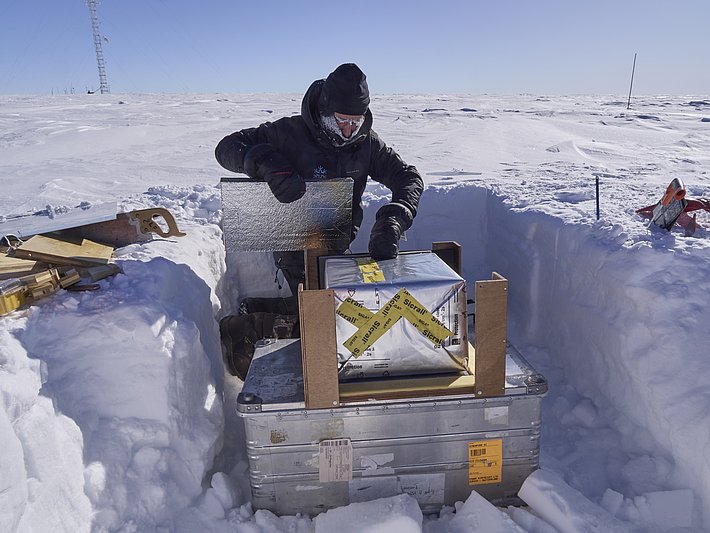 The snow block is fitted into the metamorphism box while still out in the field. The block sits on the heating plate and I insert insulation panels around it. Finally, the cover heating plate is placed on top and the block is well protected for the short journey by snowmobile to the EPICA storage facility, where the experiment will take place. (Photo: Matthias Jaggi / SLF)