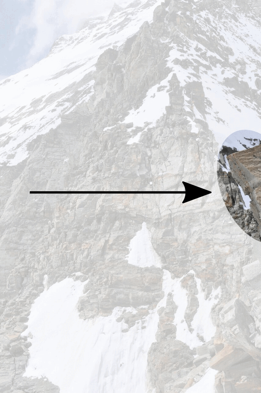 Una montagna con rocce innevate. Una freccia indica un'area in cui si stacca un grande masso.